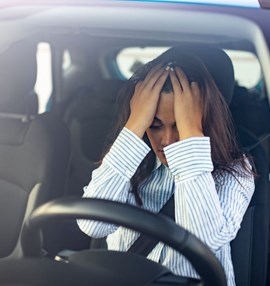 אישה מודאגת מעליית מחירי ביטוח הרכב