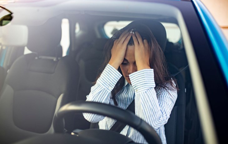 אישה מודאגת מעליית מחירי ביטוח הרכב